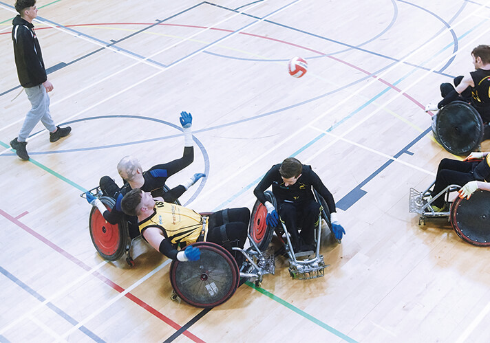 players contesting the ball in a wheelchair rugby match